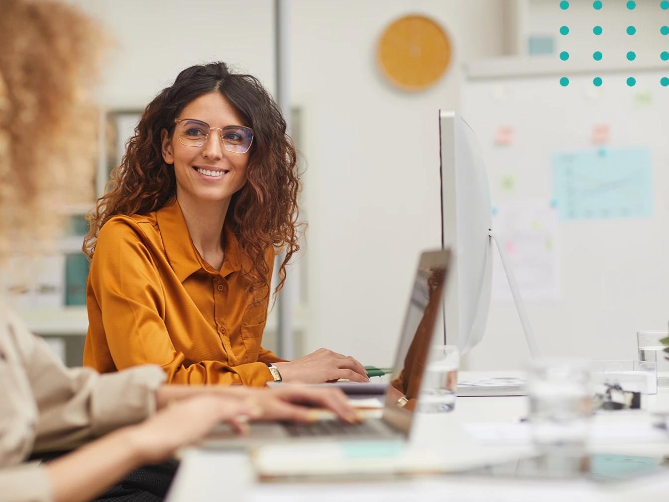 woman smiling while working at desktop computer