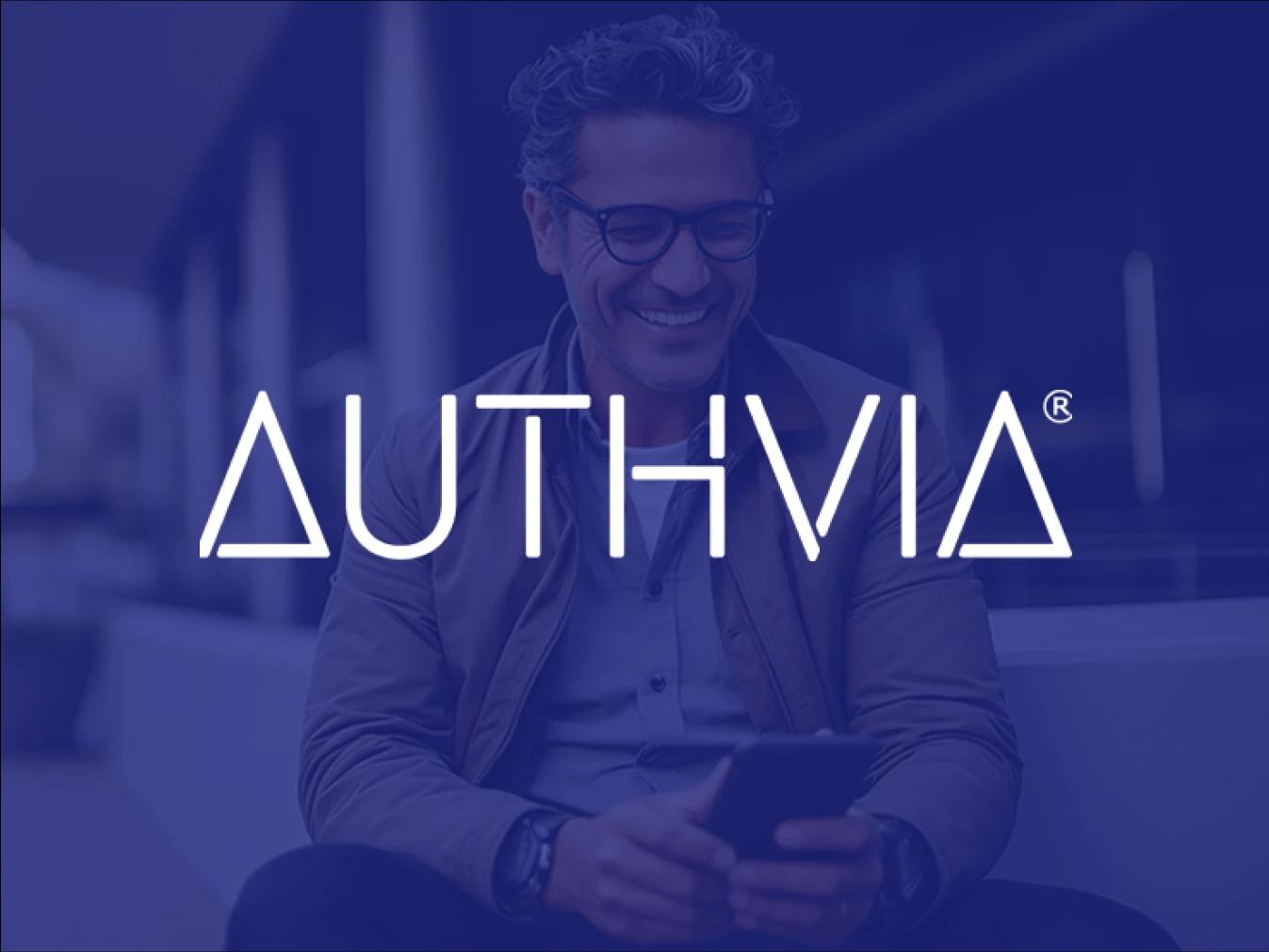 Logo for Authvia, a Business Wire customer, overlayed on an image of a man smiling