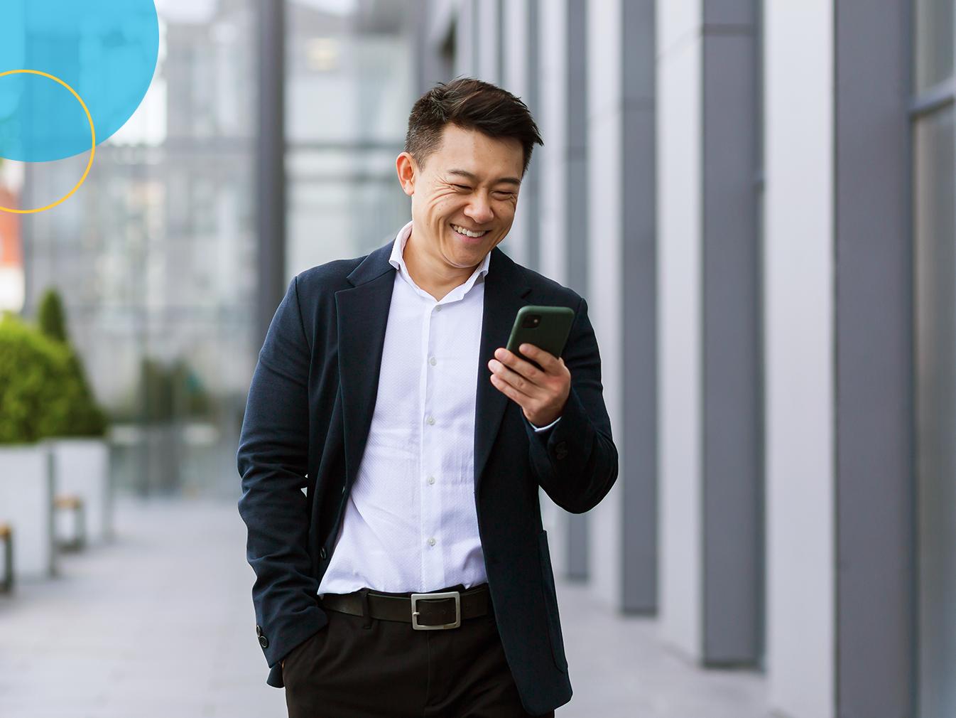 man walking while looking at mobile phone