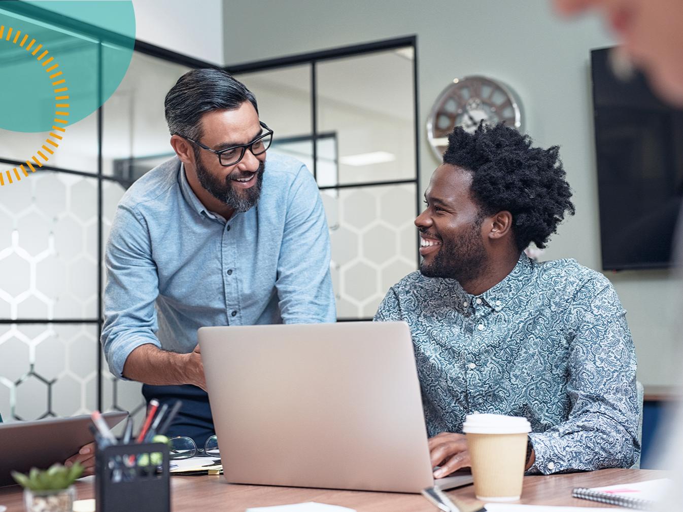 two men collaborating at a laptop